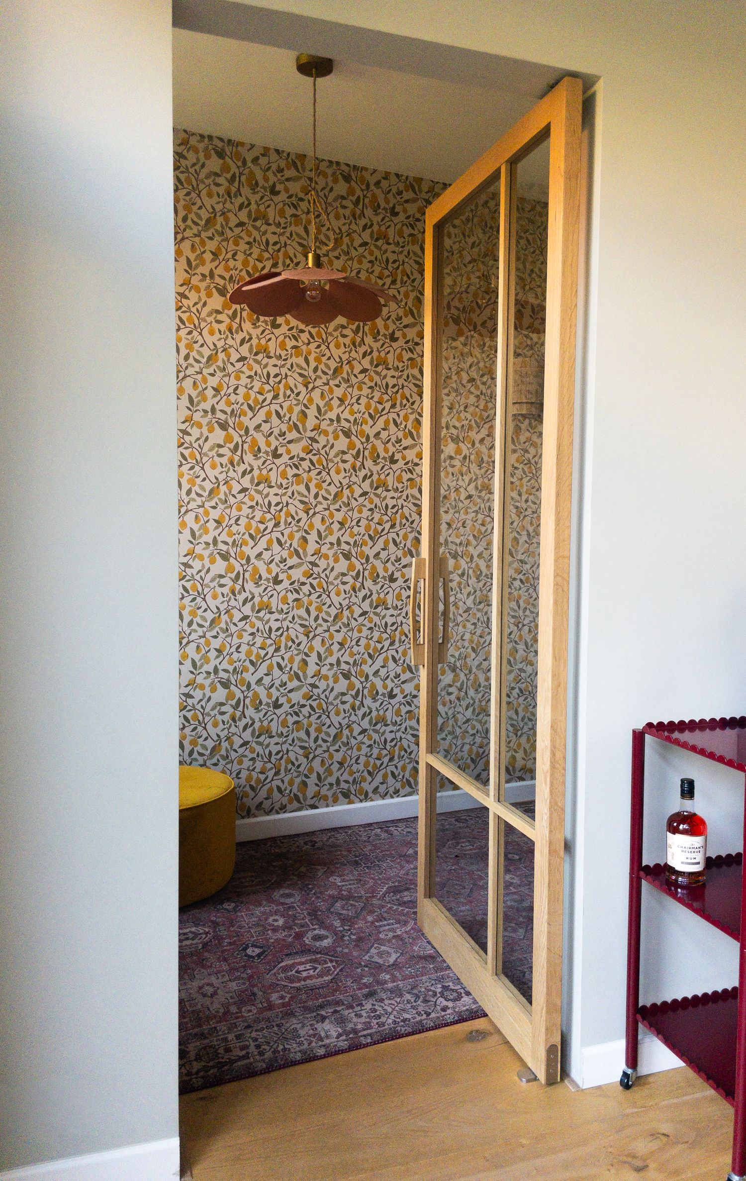 Open deur met zicht op een kamer met citroenbehang in Oegstgeest
