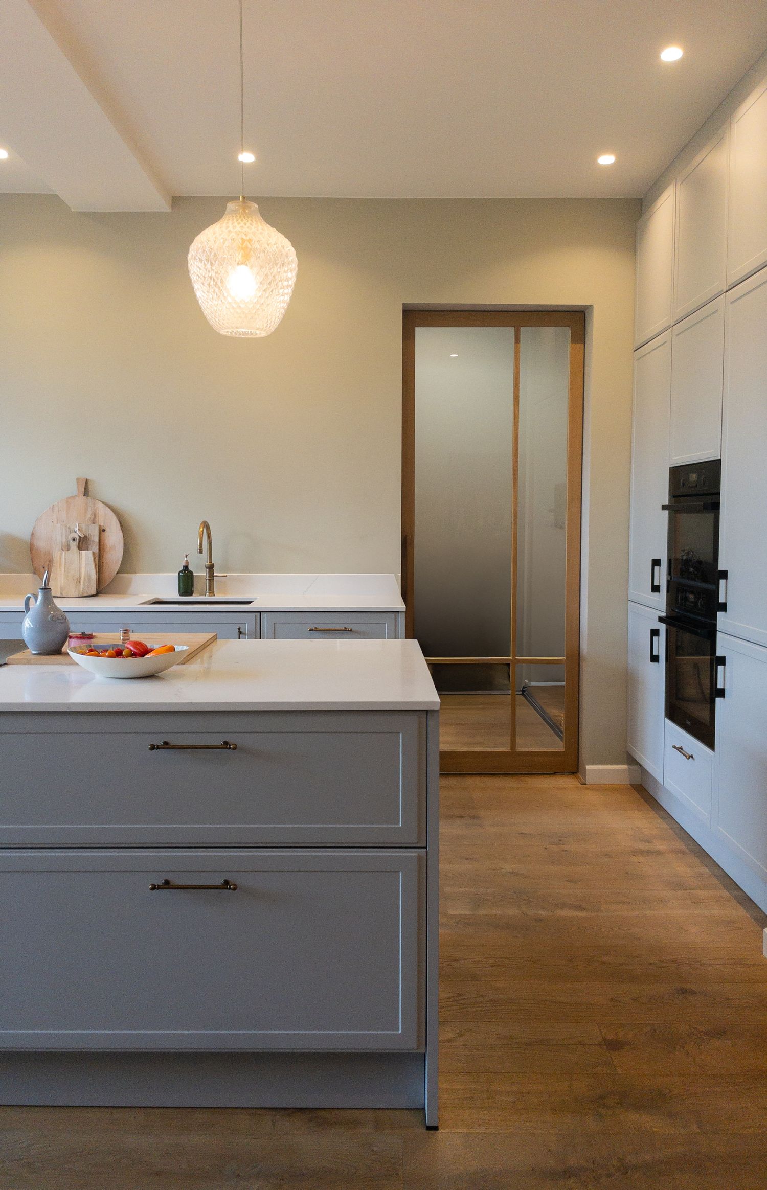 Keuken met eiland en glazen schuifdeur in Oegstgeest