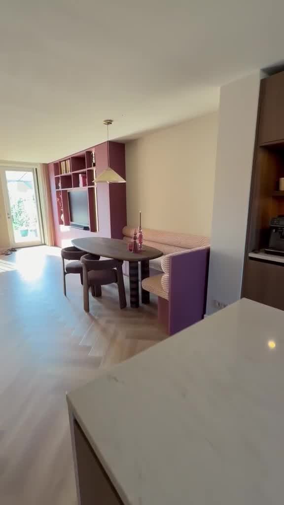 Overzicht van een woonkamer met maatwerk tv-kast en eethoek met zitbank in Schiedam
